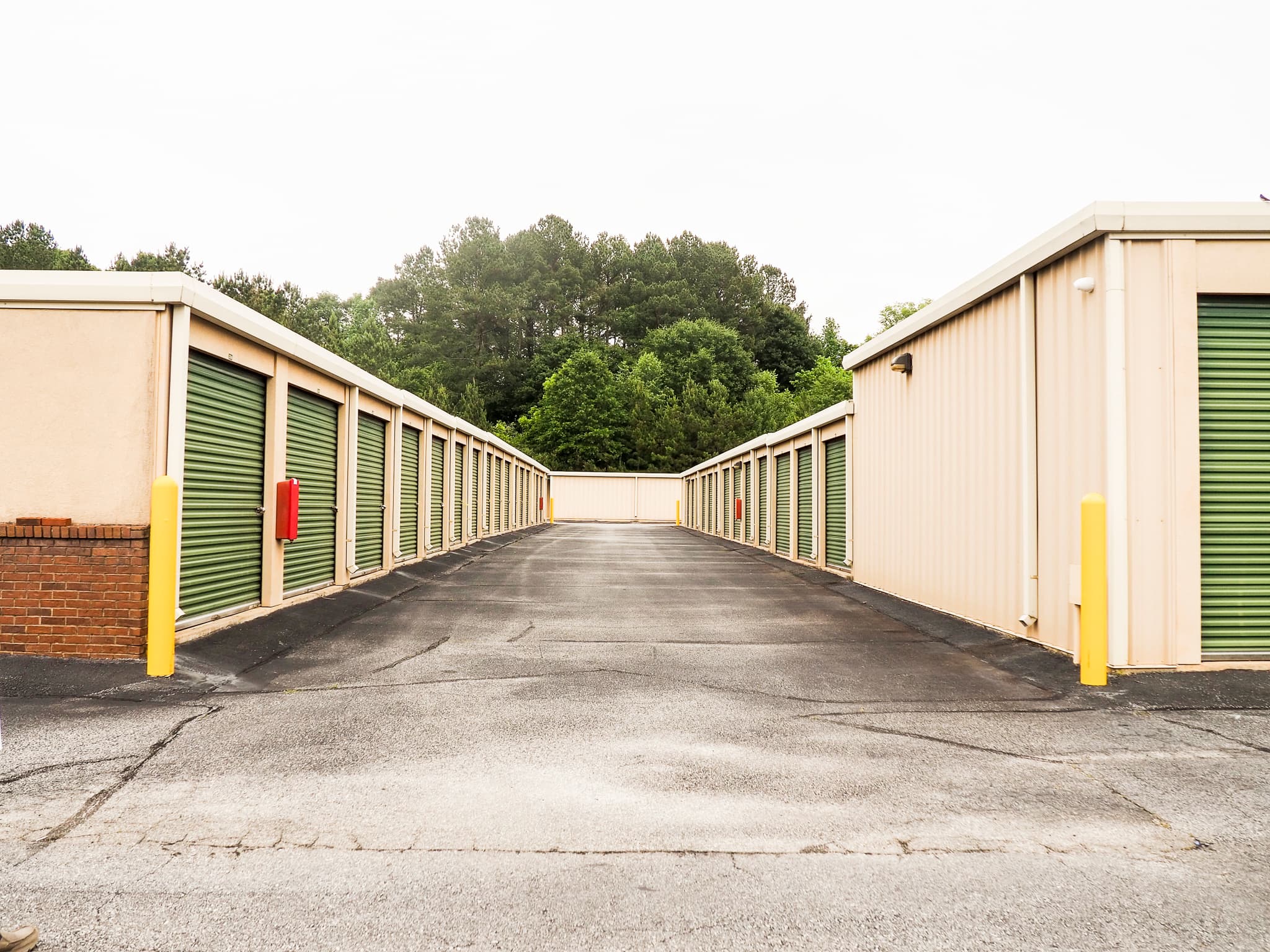 Drive aisle lined with green roll-up storage doors