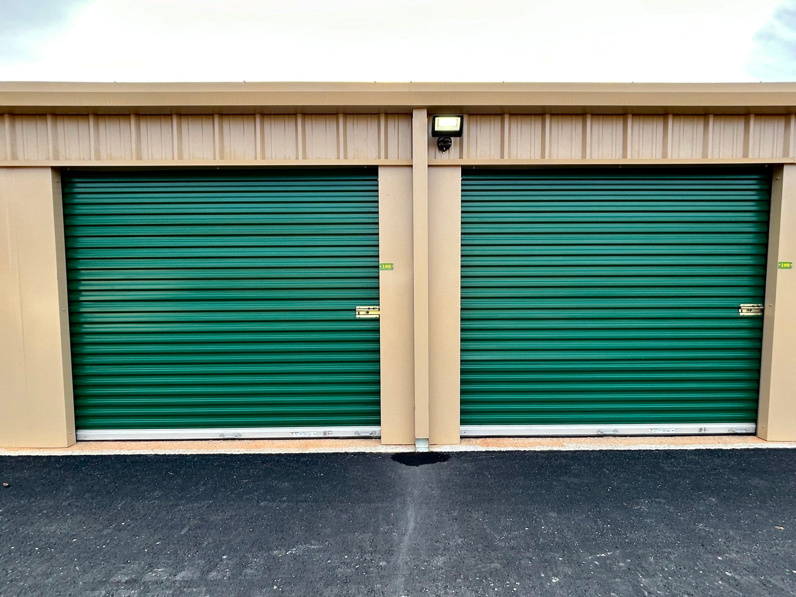 Two green roll-up storage unit doors